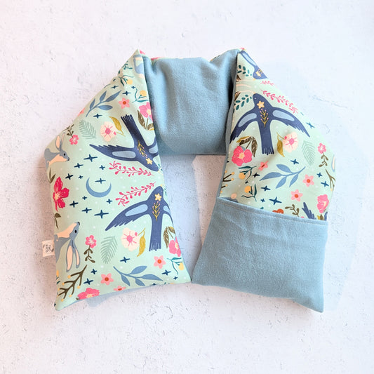 Neck pillow with floral and bird pattern on a light background